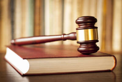 Judges wooden gavel resting on a law book in a courtroom conceptual of judgements, crime, punishment, and justice