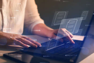 Businesswoman working on   laptop with virtual screen. Process automation to efficiently manage files. Online documentation database and  document management system concept