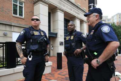 Security personnel from the Department of Homeland Security's Federal Protective Service, watch the vicinity around the Alexandria Federal Court in Alexandria, Va., on day one of Paul Manafort's trial, Tuesday, July 31, 2018. (AP Photo/Manuel Balce Ceneta)